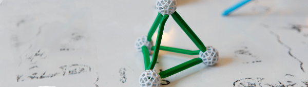 A geometrical model on top of a whiteboard with some worn-out mathematical formulae